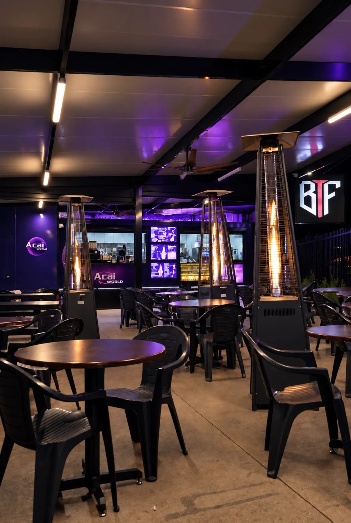 Açaí World seating area with tables and outdoor heaters